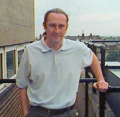colour photograph of a man against an urban skyline