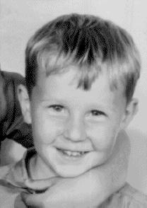 black and white photograph of a small boy smiling at the camera