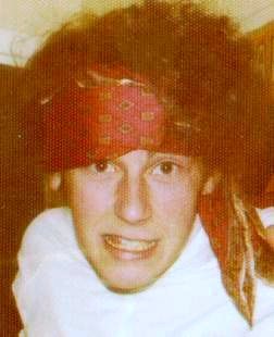 washed out colour photograph of a syouth in some sort of fancy dress pulling a face at the camera